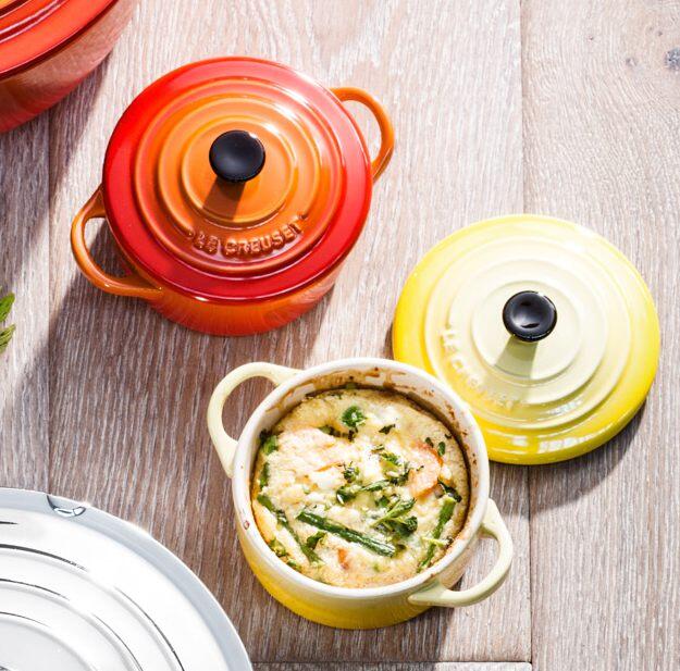 Le Creuset Mini Cocotte kirschrot mit Deckel auf Holztisch