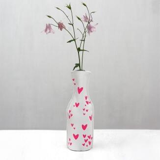 Frohstoff Flaschenhusse mit neonpinken Herzen auf weißer Flasche