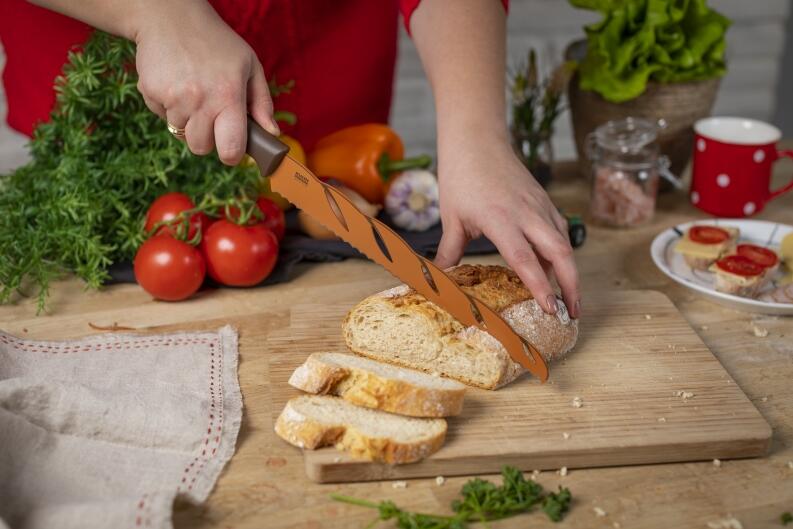 Kuhn Rikon Brotmesser braun schneidet Brot auf Holzbrett