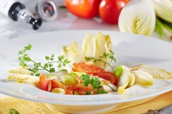 Lauwarmer Chicoréesalat mit Frühlingslauch, Tomaten und Pinienkernen